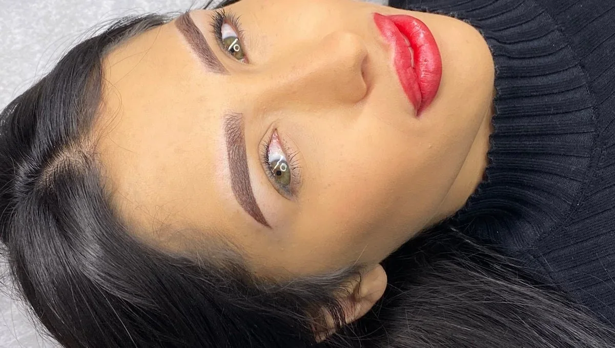 A client with soft powder brows and a red lip blush by Eliza Pino